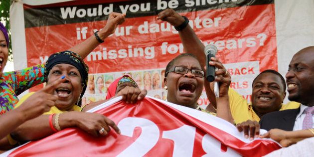 Members of the #BringBackOurGirls (#BBOG) campaign react on the presentation of a banner which shows