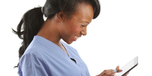 African American nurse laughing with touch pad