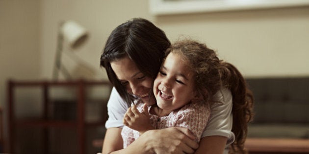 Mother and daughter having fun on sofa