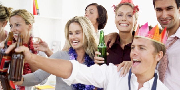 close-up of co-workers celebrating with beers at a office party