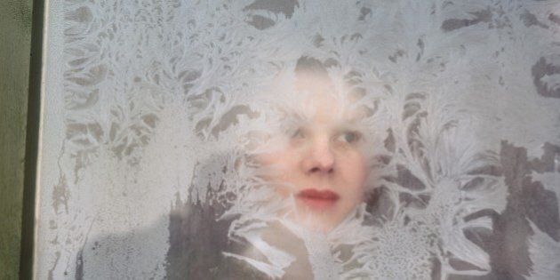 circa 1960: A woman peers through a frosty window. (Photo by Raymond Kleboe/Hulton Archive/Getty Images)