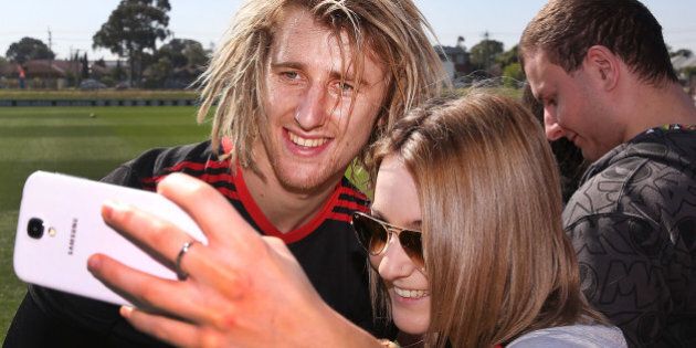 MELBOURNE, AUSTRALIA - SEPTEMBER 05: Dyson Heppell of the Bombers poses for a selfie with a fan during an Essendon Bombers AFL training session at True Value Solar Centre on September 5, 2014 in Melbourne, Australia. (Photo by Michael Dodge/Getty Images)