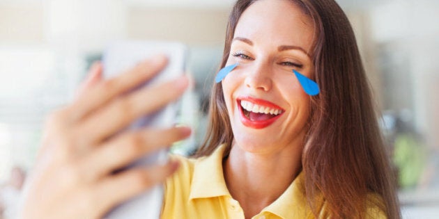 Portrait of beautiful female smiling, crying and lookining at a phone