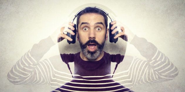 Double exposure of a man listening to music on his headphones.