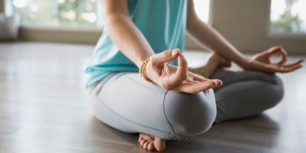 Woman in lotus position practicing mudra meditation