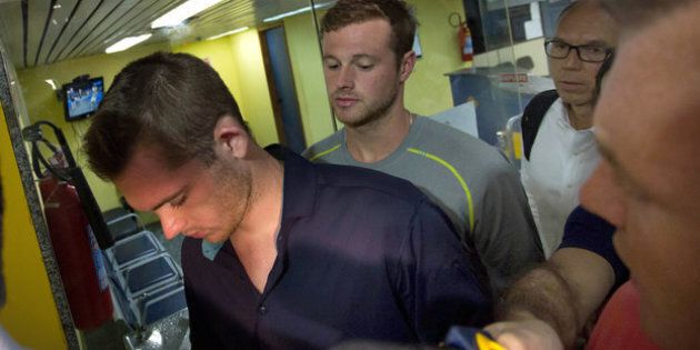 US swimmers Jack Conger (L) and Gunnar Bentz walk into a police office of Rio de Janeiro's international airport after they were stopped from boarding a flight to the United States following their participation in the Rio 2016 Olympic Games, August 17, 2016. REUTERS/Courtesy Globo TV/Handout TPX IMAGES OF THE DAY EDITORIAL USE ONLY
