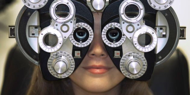 Woman's Face Behind Eye Exam Machine