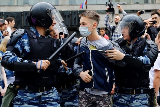 Russian riot police brandished batons and released pepper spray onto thousands of protestors in Moscow on Monday.