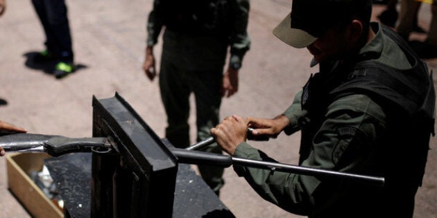 Venezuelan National Guard destroy a weapon during an exercise to disable seized weapons in Caracas.