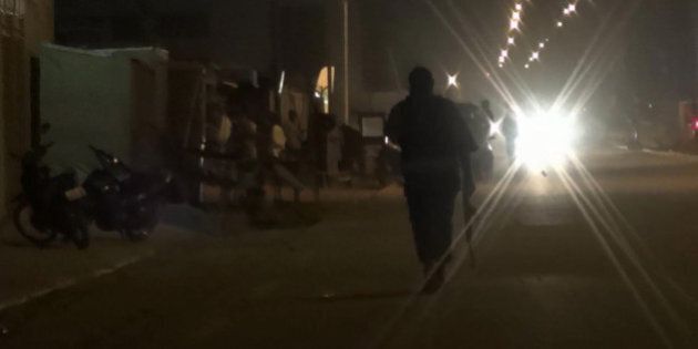 In this grab taken from video by Associate Press Television, an armed policeman patrols the area after an attack on a hotel, in Ouagadougou, Burkina Faso, Friday, Jan. 15, 2016. Attackers struck an upscale hotel popular with Westerners in Burkina Faso's capital late Friday, fueling the recent political turmoil in the West African country. Three hours later, gunfire could still be heard as soldiers in an armored vehicle finally approached the area. (Associated Press Television via AP)