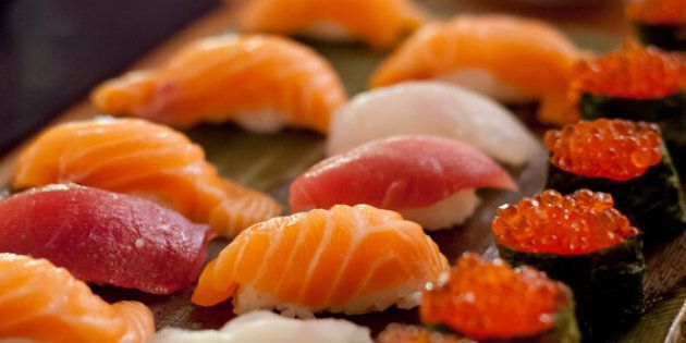 Close-up of sushi plate with salmon in tray on table.
