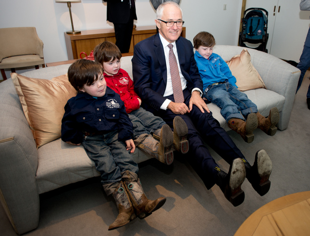 Beau Cosgrove (far left) with his brothers, comparing 'cowboy boots' with Prime Minister Malcolm Turnbull.