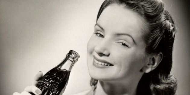 UNITED STATES - CIRCA 1950s: Teenage girl with bottle of Coca-Cola.