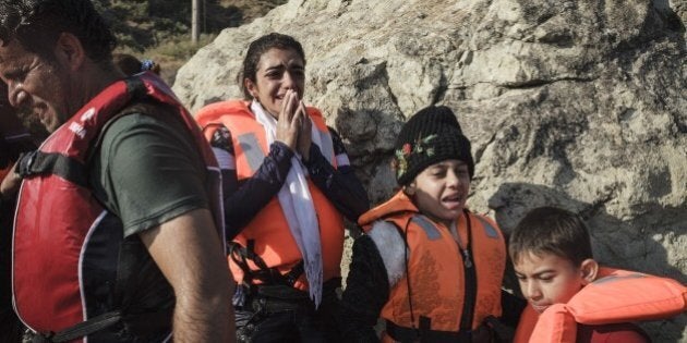 Syrian refugees react upon arrival on Lesvos island in Greece, after having crossed the Aegean sea from Turkey in an inflatable boat, on August 23, 2015. AFP PHOTO / ACHILLEAS ZAVALLIS (Photo credit should read ACHILLEAS ZAVALLIS/AFP/Getty Images)