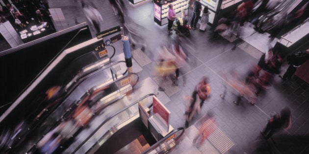 Large number of people (motion blurred) shopping and traveling at Melbourne Central Shopping Centre, Australia. Melbourne Central is a large shopping centre, office and public transport hub, refurbished in 2005 by architects Ashton Raggatt McDougall.