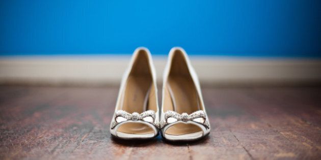 Cute shoes with bow tie on wood floor with blue background.