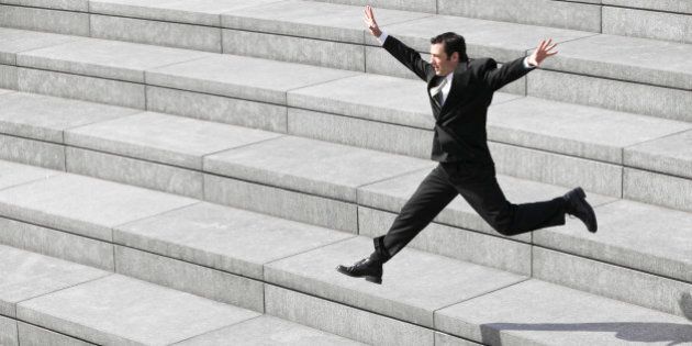 Businessman leaping on steps