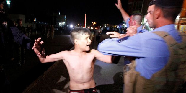 Iraqi security forces detain a boy after removing a suicide vest from him in Kirkuk, Iraq, Aug. 21, 2016.