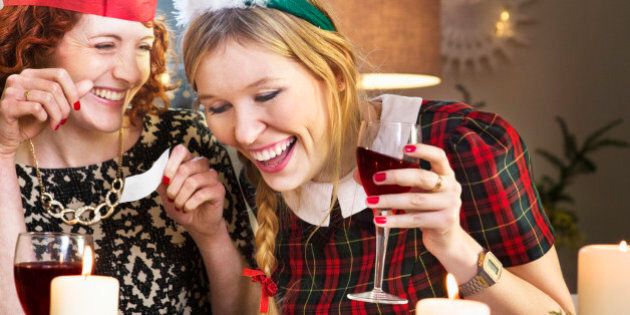 Friends laughing at joke at Christmas dinner table