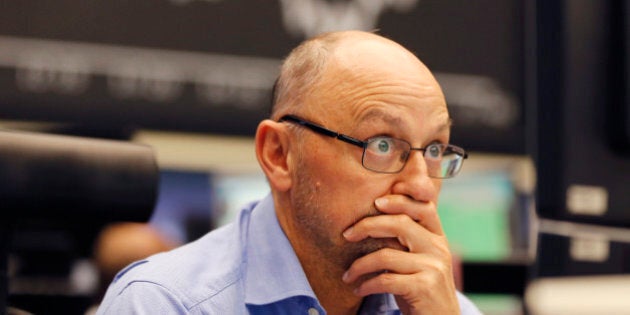 A trader watches his screens when the curve of the German stock index DAX fell under 10,000 points at the stock market in Frankfurt, Germany, Monday, Aug. 24, 2015. (AP Photo/Michael Probst)