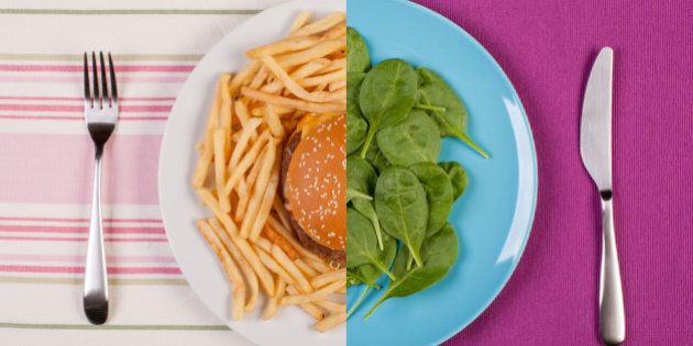 stock image of low fat healthy spinach leaves against unhealthy greasy burger with french fries. diet concept