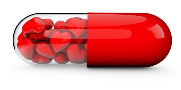 3D render of a pill tablet filled with red love hearts