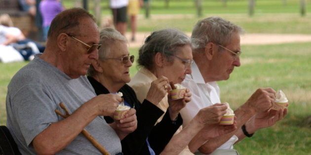 Four pensioners sat on a park bench eating ice cream, Stratford upon Avon, UK. (Photo By: Education Images/UIG via Getty Images)