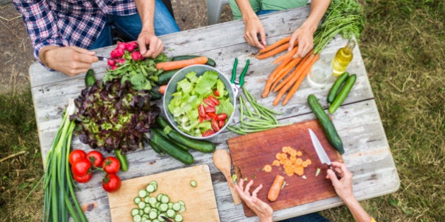 Family preparing fresh salad in a garden