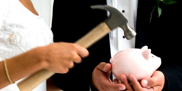 Bride and groom breaking piggy bank