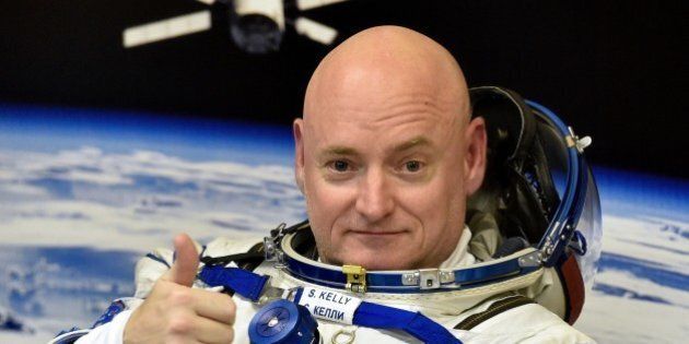 US astronaut Scott Kelly gestures as his space suit is tested at the Russian-leased Baikonur cosmodrome, prior to blasting off to the International Space Station (ISS), late on March 27, 2015. The international crew of US astronaut Scott Kelly and Russian cosmonauts Gennady Padalka and Mikhail Kornienko is scheduled to blast off to the ISS from Baikonur early on March 28. AFP PHOTO / KIRILL KUDRYAVTSEV (Photo credit should read KIRILL KUDRYAVTSEV/AFP/Getty Images)