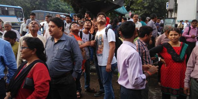 People stand outside their offices after they rushed outdoors following tremors in Kolkata, India.