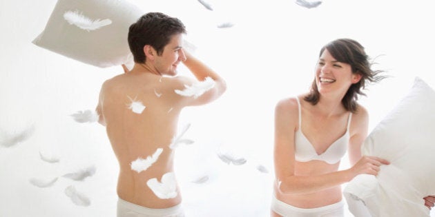 Couple in underwear enjoying pillow fight