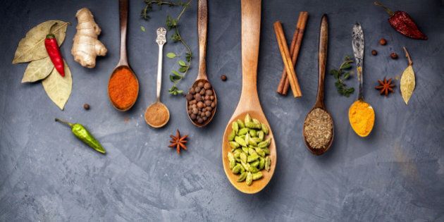 Various Spices like turmeric, cardamom, chili, bayberry, bay leaf, ginger, cinnamon, cumin, star anise on grunge background with space for your text