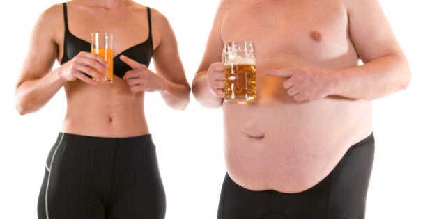 Young slim woman beneath a very fat man, both drinking orange juice and beer