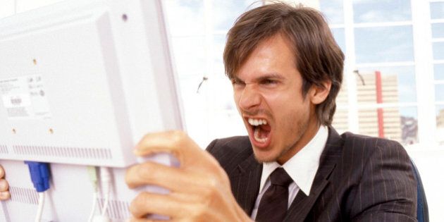 Businessman yelling at a computer monitor