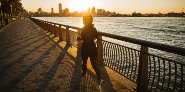 Woman jogging along the East River in Manhattan, New York, United States, North America.