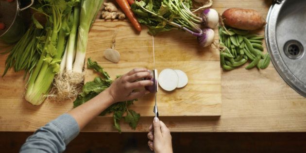 High angle shot of a woman cutting up vegetables on a cutting board