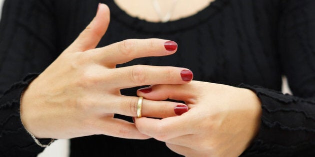 break up . Woman is taking off the ring from hand