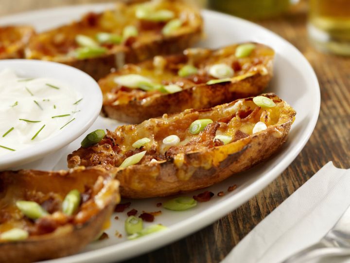 Bacon and cheddar stuffed potato skins with sour cream.