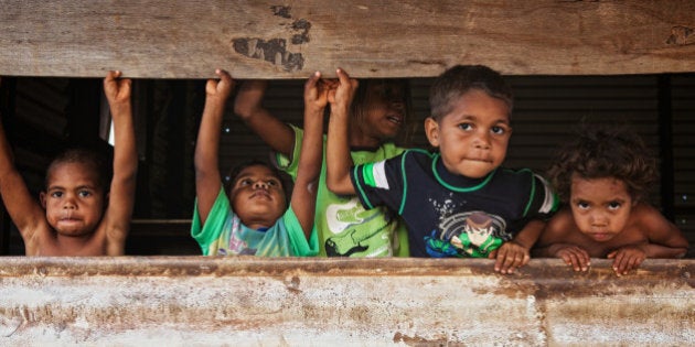 Aboriginal brothers and sisters playing in shed.