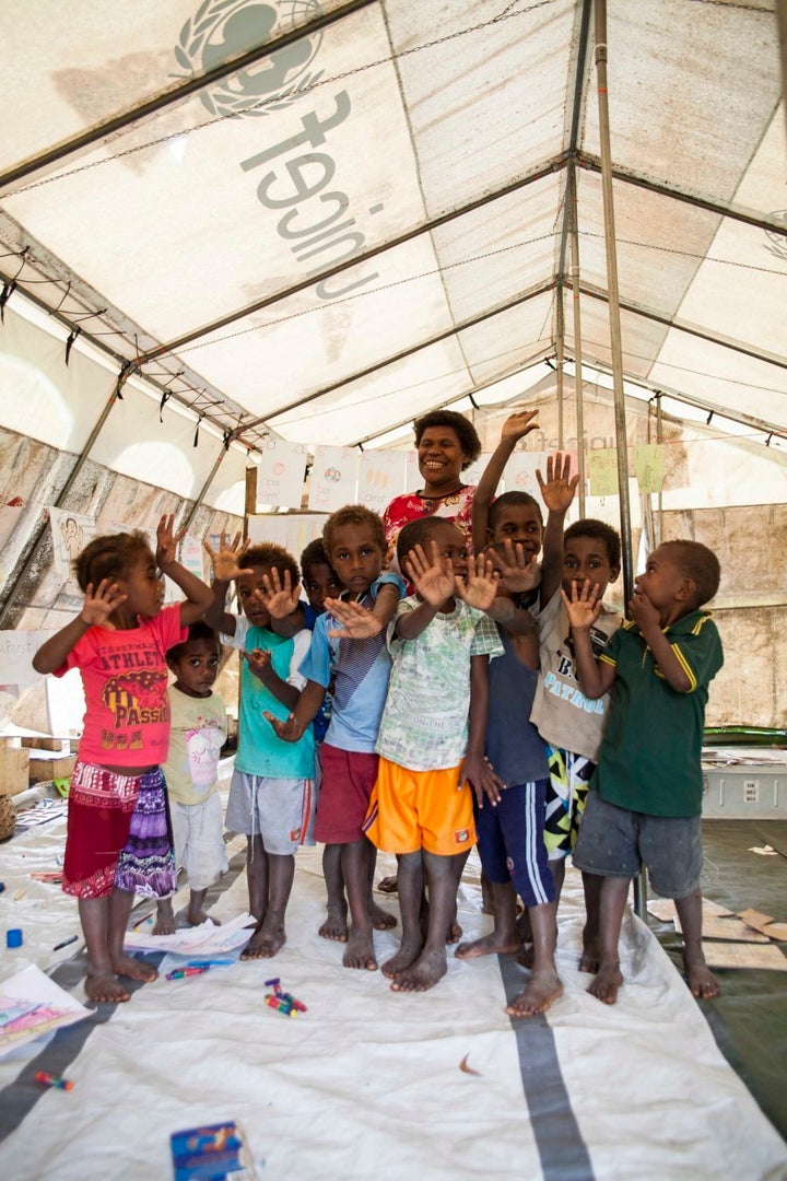 Kids from Loubukas Kindergarten sing and dance under the cover of a UNICEF tent after their schoolhouse was destroyed in Cyclone Pam. They have been given until 2018 to rebuild it, through their own funding and no government support. If this deadline isn't met they will be shut down.