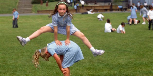 Children playing leapfrog in playground of primary school, Isle of Man UK. (Photo by: Photofusion/UIG via Getty Images)