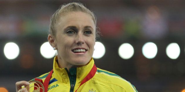 Sally Pearson of Australia winner of the women's 100 meter hurdle race poses for photographs on the podium following the medal ceremony for the event at Hampden Park Stadium during the Commonwealth Games 2014 in Glasgow, Scotland, Saturday Aug. 2, 2014. Pearson won the race Friday.(AP Photo/ Scott Heppell)