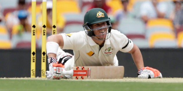 Australia's David Warner falls down after playing a shot during play on day one of the first cricket test between Australia and New Zealand in Brisbane, Australia, Thursday, Nov. 5, 2015. (AP Photo/Tertius Pickard)