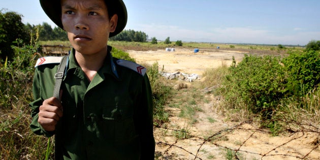 A Vietnamese soldier guards the contaminated site at the edge of the Da Nang Airfield on July 1, 2009 in Da Nang, Central Vietnam. During the Vietnam War, the U.S. military stored more than four million of gallons of herbicides, including Agent Orange, at the military base that is now a domestic and military airbase.