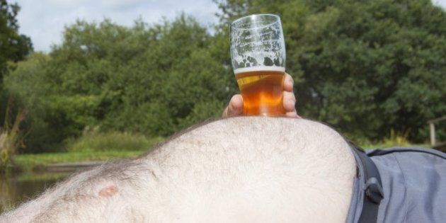 Obese Man With A Glass Of Beer Sunbathing