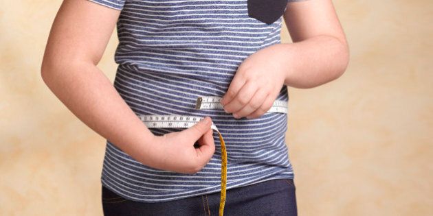 Obese child measuring herself