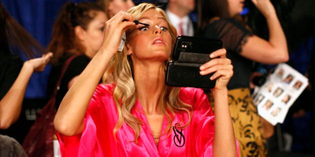 Model Erin Heatherton from the U.S. applies eye makeup backstage before the 2011 Victoria's Secret Fashion Show in New York November 9, 2011. REUTERS/Mike Segar (UNITED STATES - Tags: FASHION)