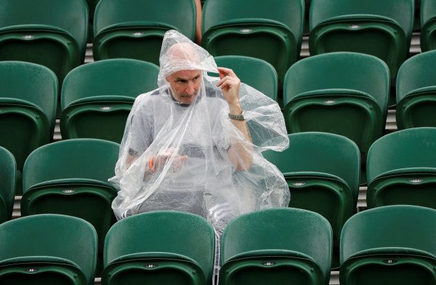 One die-hard fan sticks out the rain delay, equipped with rain poncho.