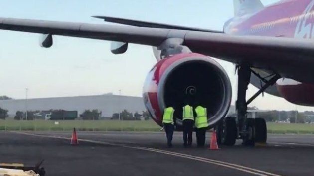 AMSA officers inspect the engine of the Air Asia X jet, which is believed to have been damaged by birds.